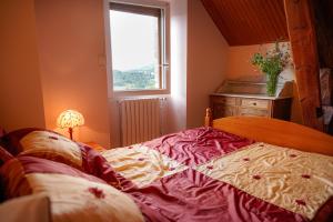 a bedroom with a large bed and a window at Gîte le marlet in Saint-Alban-sur-Limagnole