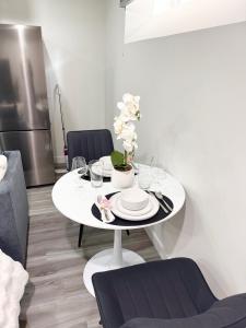 a white table with plates and dishes on it in a kitchen at Velvet and Rose Elegant Private 2BR Basement Suite in Winnipeg