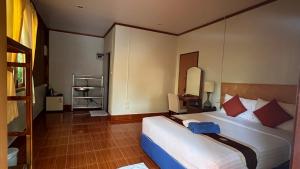 a hotel room with a bed and a mirror at Poonsap Resort in Ko Lanta