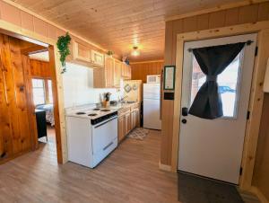 a kitchen with a white stove top oven next to a door at 2BR 1BA Cabin #2 Riverside Point Resort in Park Rapids