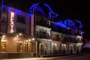 un edificio con un'insegna al neon di fronte di Hotel Bellavista & Spa a Bukovel