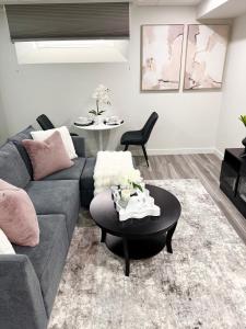 a living room with a couch and a table at Velvet and Rose Elegant Private 2BR Basement Suite in Winnipeg