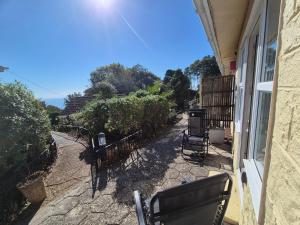 a patio with chairs and trees and a building at Westcliffe chalets channel view in Niton +6 photos