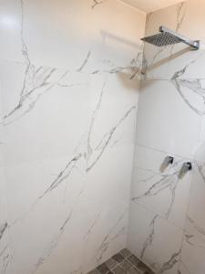 a bathroom with white marble walls and a shower at El Suburbio - Aldama in Morelia +39 photos