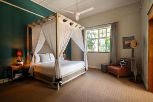 a bedroom with a canopy bed and a chair at Nine Skies By Teardrop Hotels in Ella