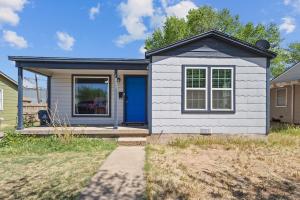 a small white house with a blue door at YeeHaw BnB in Amarillo