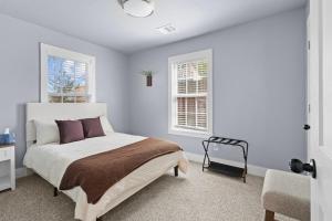 a bedroom with a bed and a chair and two windows at YeeHaw BnB in Amarillo