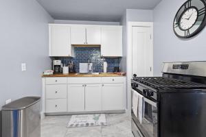 a kitchen with white cabinets and a clock on the wall at YeeHaw BnB in Amarillo