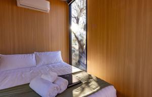 a bedroom with a bed with a laptop and a window at Auburn Vale Cottage by Tiny Away in Quirindi