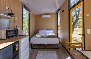 a small bedroom with a bed in a tiny house at Auburn Vale Cottage by Tiny Away in Quirindi