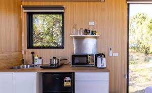 a small kitchen with a microwave and a sink at Auburn Vale Cottage by Tiny Away in Quirindi