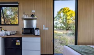 a kitchen with a counter with a microwave and a window at Auburn Vale Cottage by Tiny Away in Quirindi +33 photos
