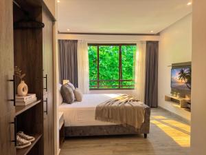a bedroom with a bed and a large window at Hotel NEON by Playa Palmera Beach Resort in Punta Cana +61 photos