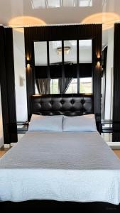 a bedroom with a large bed with a black headboard at Sashii Hostel & Boutique. in Ríohacha