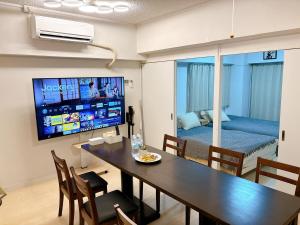 a living room with a dining room table and a bedroom at GoodStay505 in Kurume