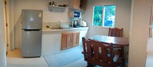 a kitchen with a stainless steel refrigerator and a table at Elevated Bungalow House 5 min from the beach 3-6 in Nathon Bay
