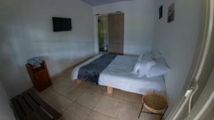 a small bedroom with a bed and a television at Refugio en la naturaleza in La Vega +26 photos
