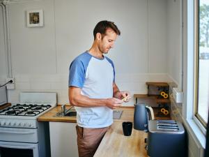 a man standing in a kitchen preparing food at Collie Tourist Park in Collie