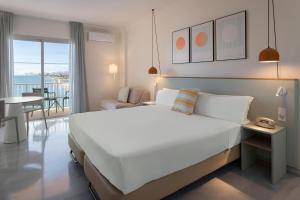 a bedroom with a large white bed and a balcony at SOL by Meliá Málaga Guadalmar in Málaga