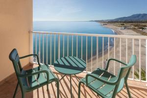 two chairs and a table on a balcony with the beach at SOL by Meliá Málaga Guadalmar in Málaga