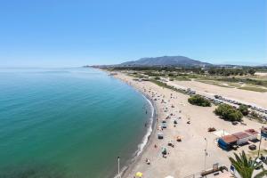 a view of a beach with people and the ocean at SOL by Meliá Málaga Guadalmar in Málaga