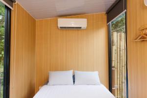 a bed in a small room with a window at Cedar Creek Falls by Tiny Away in Mount Tamborine