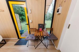 a table with a laptop on it in front of a door at Cedar Creek Falls by Tiny Away in Mount Tamborine +26 photos