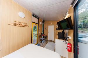 a small room with a bed and a tv in it at Cedar Creek Falls by Tiny Away in Mount Tamborine