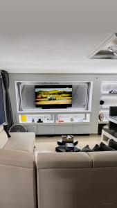 a living room with a couch and a flat screen tv at Sashii Hostel & Boutique. in Ríohacha