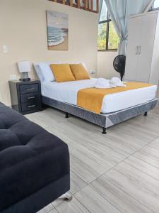 a bedroom with a large bed and a couch at Glampings Boreal in Mompiche +11 photos