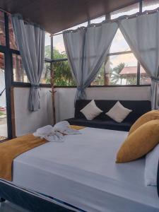 a bed with white sheets and pillows in a bedroom at Glampings Boreal in Mompiche