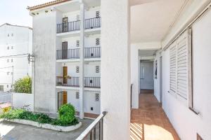 an apartment balcony with a white building at Apto Nidos cerca de la playa in L'Escala