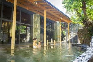 a woman and a child in a swimming pool at Ooedo Onsen Monogatari Premium Shirahama Gyoen in Shirahama