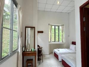 a white bedroom with two beds and a mirror at Skyville Zen Resort,Kundasang in Kampong Kundassan +11 photos