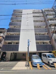 a parking lot in front of a building with solar panels at Namba Ebisu Tower701 in Osaka