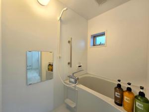 a bathroom with a tub and a shower with a mirror at 鶴城丸（KAKUJYOMARU） in Karatsu +14 photos