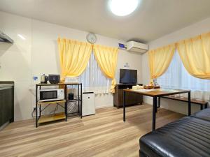 a room with a bed and a desk with a tv at 鶴城丸（KAKUJYOMARU） in Karatsu