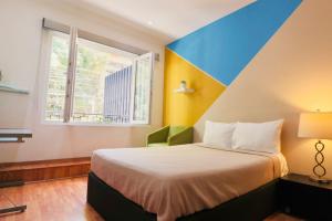 a bedroom with a bed and a large window at MRE Goldsmith Polanco in Mexico City