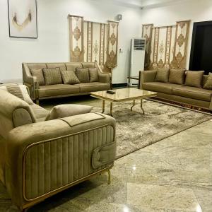 a living room with couches and a coffee table at perficient apartments in Okpanam