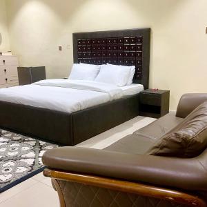 a bed and a couch in a room at perficient apartments in Okpanam