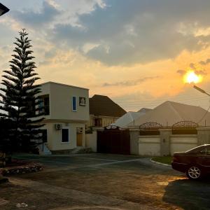a car parked in a parking lot next to a house at perficient apartments in Okpanam