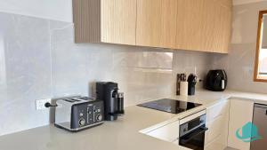 a kitchen with a coffee maker on the counter at Wangi Waterfront Weekender in Wangi Wangi +20 photos