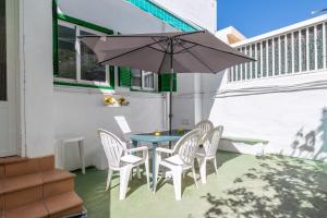 a table and chairs with an umbrella on a patio at Nafeti in Palma de Mallorca