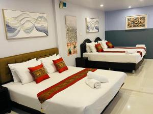 a hotel room with two beds with white and red pillows at Pongsakorn Boutique Resort in Lat Krabang