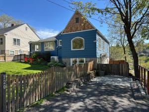 a blue house with a wooden fence at State Street Cottage, Suite 1 in Pullman