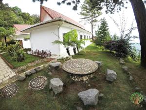 a garden with rocks in front of a house at Skyville Zen Resort,Kundasang in Kampong Kundassan