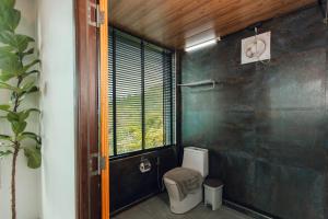 a bathroom with a toilet and a window at Sinsup villa Mountain View 1 in Ban Huai Khai