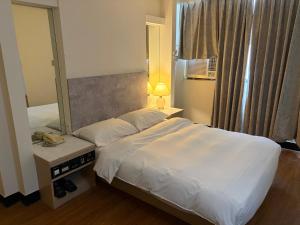 una camera da letto con un grande letto e uno specchio di 東城年代旅舍中山館 a Taichung Altre 6 foto