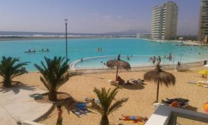 una gran piscina con gente en la playa en Laguna del Mar Apartamento 208, en La Serena