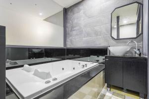 a large bathroom with a tub and a sink at Pandora Hotel in Hwaseong